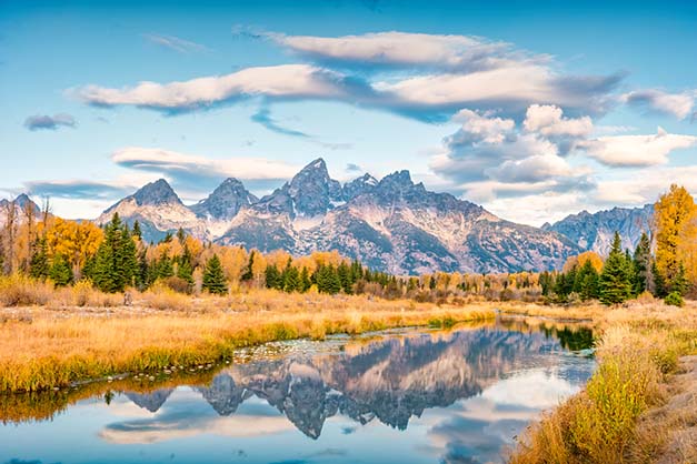 Grand Teton with its reflection in the Snake River at Schwabacher Landing in Grand Teton National Park, Wyoming at sunrise.