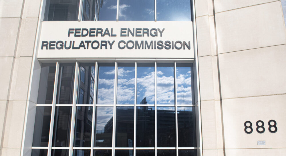 Entrance to the FERC building. Reflection of clouds and blue sky in the glass doors.