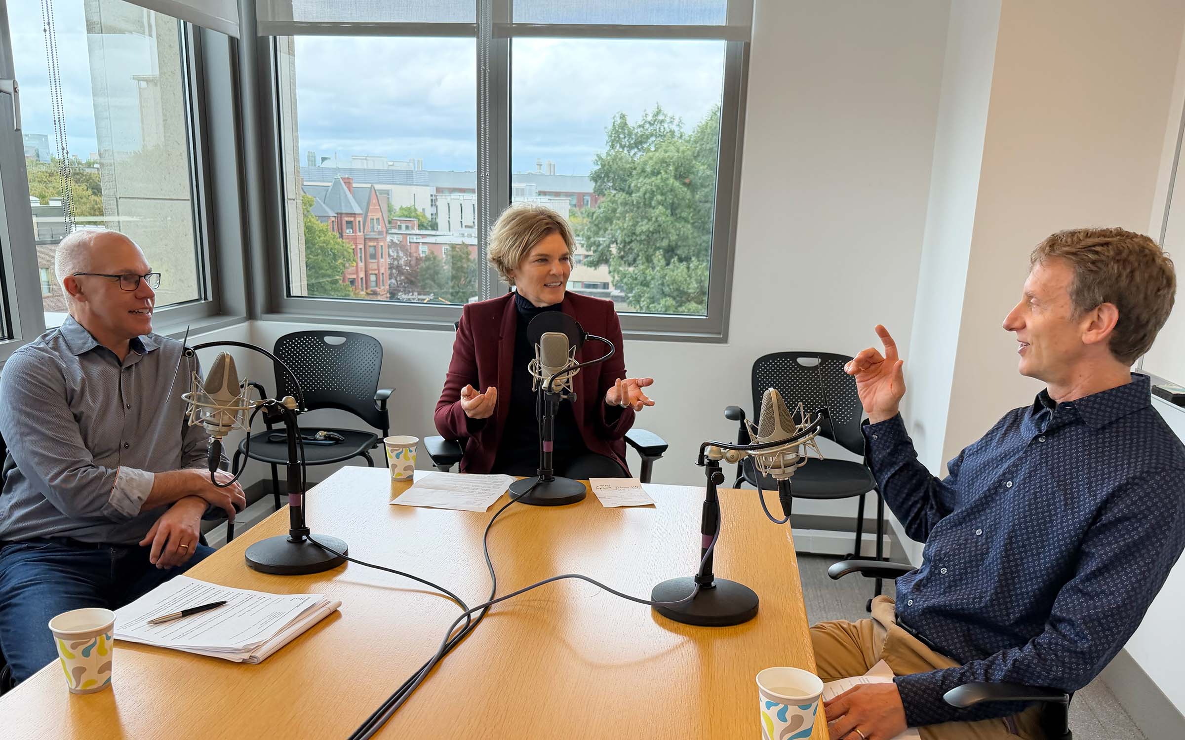 Jody Freeman, Joe Aldy, and Mike Toffel talking and smiling as they record a podcast.
