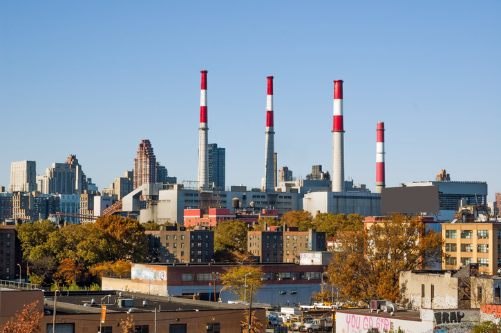 Smoke stacks and power plant in a urban area on a clear autumn day.